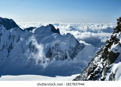 Sunset in mountains. Reflection of red sun on mountain snow peaks and clouds. Altai, Belukha area