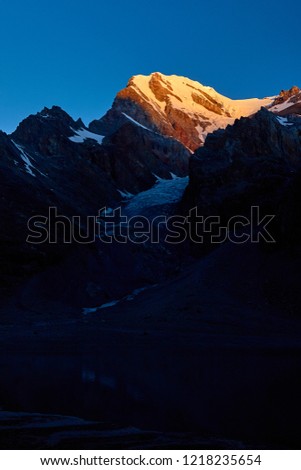 Sunset in mountains. Reflection of red sun on mountain snow peaks, Fann, Pamir Alay, Tajikistan