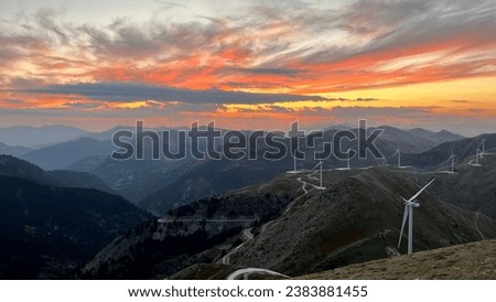 Sunset in the mountains with valley and wind turbines