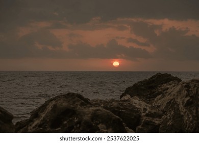 Sunset Ocean Rocks - Orange sunset over ocean viewed from rocky coastline. - Powered by Shutterstock