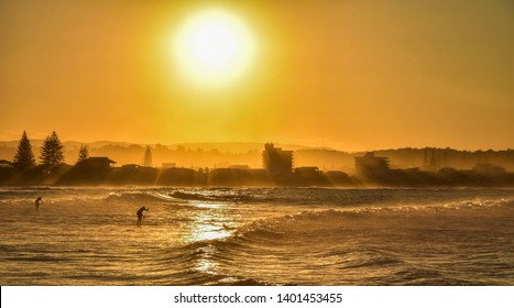the sunset on the Australian coasts while surfing and sup in a photo that has not had any color retouching