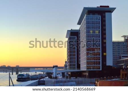 Sunset on the banks of the Ob. Modern residential buildings near the river station. Novosibirsk, Siberia, Russia, 2022