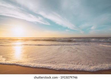 Sunset on the beach. Beautiful tranquil scene of empty sand beach, turquoise colored water, and cloudy sky - Powered by Shutterstock