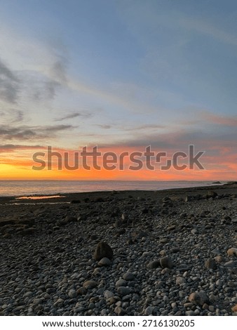 Sunset on the beach, with orange and reddish clouds