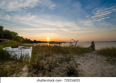 Sunset On The Chesapeake Bay With Wooden Boat On The Beach