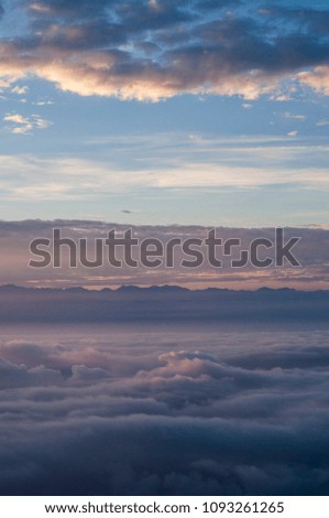 Sunset on the clouds seen from a plane flying above Asia.
