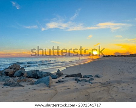 Sunset on an empty beach in East Hampton, New York in November 2023.  Beautiful colors and waves crashing. Landscape.