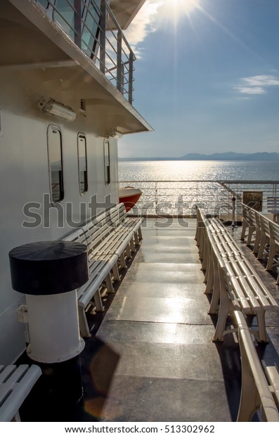 Sunset on\
a empty ferry boat with white plastic\
seats