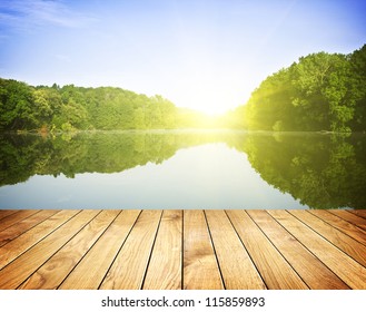 Sunset On Forest Lake And Wooden Board Background