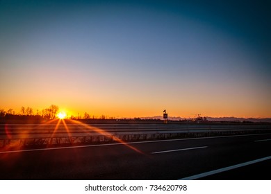 Sunset On The Highway In Front Of An Industry