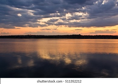 Sunset On The Horizon With A River In Ukraine With Reflection Of Clouds In Water