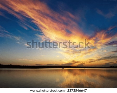 Sunset on the lake, reflections and colorful clouds