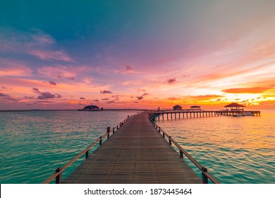 Sunset on Maldives island, luxury water villas resort and wooden pier. Beautiful sky and clouds and beach background for summer vacation holiday and travel concept. Paradise sunset sunrise landscape - Powered by Shutterstock