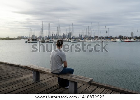 sunset on the pier of st. Kilda with boat at the harbor and Melbourne in the Background
