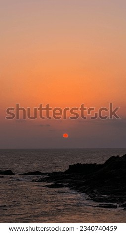 Sunset on a pleasant evening in a rocky beach.