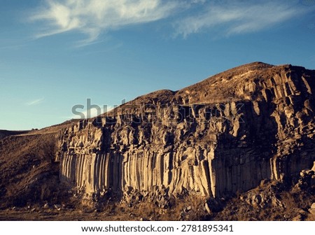 Sunset on the red cliffs of columnar basalts from Racos, Romania, Eastern Europe.