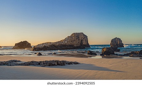 Sunset on rocky beach with clear sky. - Powered by Shutterstock