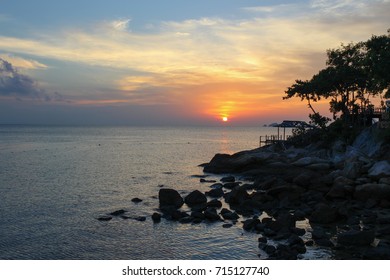 Sunset on the sea with rocks and trees in Perhentian Kecil island, Malaysia