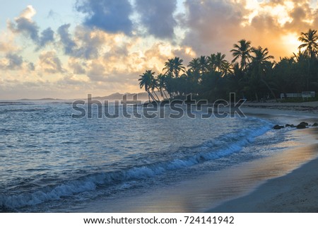 sunset on St. Croix with bright  blue ocean orange clouds and reflection in water