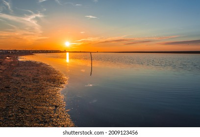 sunset on stagnant river, sunset in calm lake with sandy coast, sun reflection on stagnant lake, stagnant water