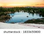 Sunset over alpine lake and snowy mountain in high altitude near Yellowstone National Park in Wyoming, off of Beartooth Highway between Red Lodge and Yellowstone National Park.