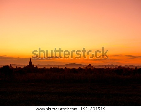 Sunset over ancient temples, pagodas and stupas in Old Bagan (Pagan), Myanmar (Burma). Peaceful Asian landscape with iconic Buddhist temple silhouettes. Sacred, serene golden sun & beautiful scenery.
