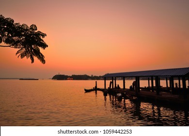 Sunset over boat jetty in Vembanad Lake in Marine Drive, Kochi.