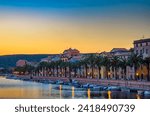 Sunset over Bosa with palm trees and colorful buildings along the Temo River in Sardinia, Italy