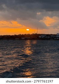 Sunset over calm harbor with dramatic clouds and reflections creating a serene evening background. Mobile photo