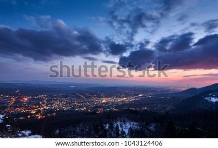 Sunset over a city. The sky is colorful and full of clouds.