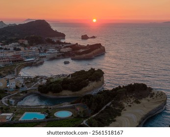 Sunset over a coastal village with unique rock formations and calm ocean waters. - Powered by Shutterstock