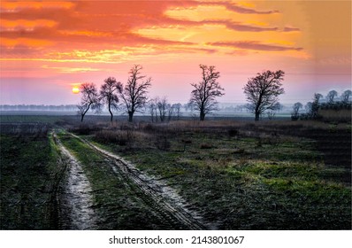 Sunset over the countryside road. Country sunset sky landscape. Rural scene at sunset. Sunset sky in countryside