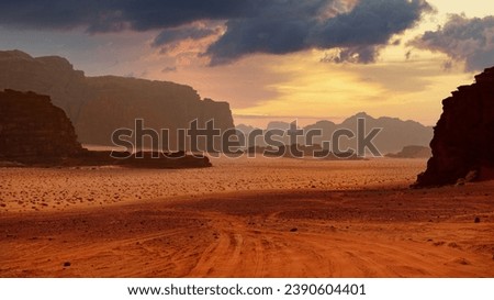 Sunset over a desert with rock formations and scattered clouds. Dramatic sky. Panoramic wallpaper of Wadi Rum desert, Jordan.