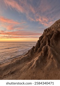 Sunset over the dramatic cliffs of Sunset Cliffs Natural Park in San Diego, California, highlighting the rugged coastline and vibrant sky during golden hour