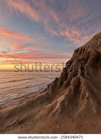 Sunset over the dramatic cliffs of Sunset Cliffs Natural Park in San Diego, California, highlighting the rugged coastline and vibrant sky during golden hour