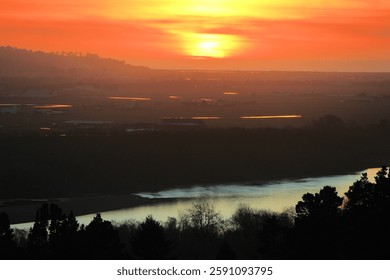 Sunset over the Eel River surrounded by a riparian woodland on the Northern California Coast taken at rural grasslands in Humboldt County near Eureka, CA