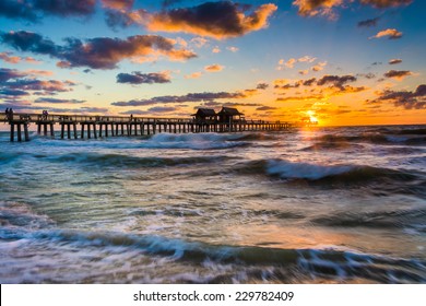 Sunset over the fishing pier and Gulf of Mexico in Naples, Florida.
