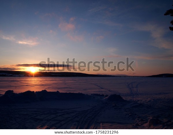 Sunset over frozen lake in\
Sweden