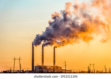 Sunset over the industrial city.Factory chimneys smoke.Environmental problem of environmental and atmospheric pollution.Climate change,environmental disaster.The sky is smoky with toxic substances
