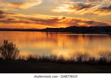 Sunset over Inks Lake State Park Burnet Texas, USA. The golden light reflects off of the sky and the water at the end of a perfect day.