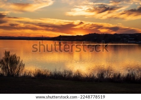 Sunset over Inks Lake State Park Burnet Texas, USA. The golden light reflects off of the sky and the water at the end of a perfect day.