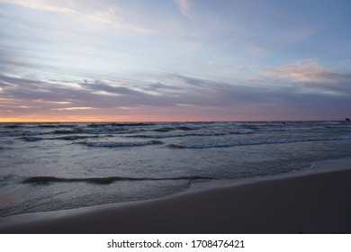 Sunset over Lake Michigan with wave crashing on beach