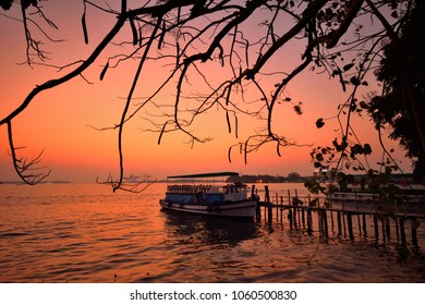 Sunset over lake Vembanad in Marine Drive, Kochi with tourist boats in the background