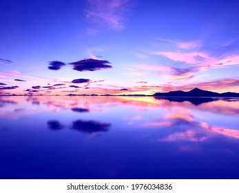 Sunset over lake. Wonderful sunset in mountains. Surreal natural landscape at salt flat Salar de Uyuni. Bright colors of desert. Incredible sky clouds reflection in calm water. Magical alien nature. - Powered by Shutterstock