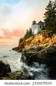 Sunset over the lighthouse on the cliff. Dramatic seascape with Bass Harbor Head Light Station in Tremont, Acadia National Park, Maine