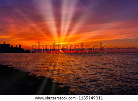 Sunset over Malecon and Atlantic Ocean with visible sun rays - Havana, Cuba 
