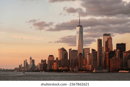 Sunset over Manhattan. Landscape photo from the ferry, view to New York skyline landmarks skyscrapers office buildings under a beautiful sunset sky. Travel to America. - Powered by Shutterstock