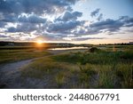 Sunset over marsh with low clouds on a summer night.