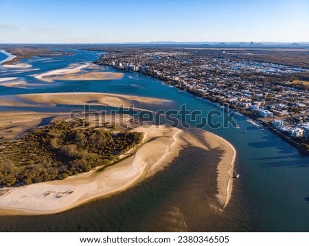 sunset over north bribie island and caloundra in south east queensland, australia; people passing to the island during low tide; Pumicestone Passage