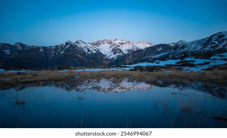 Sunset over the Pyrenees mountains with the reflection of the peaks in the water of the lake High quality 4k footage